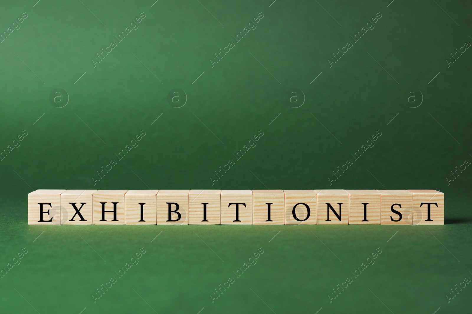 Photo of Word EXHIBITIONIST made with wooden cubes on dark green background