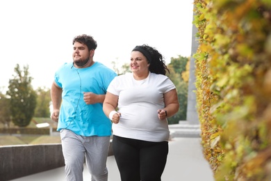 Overweight couple running together in park