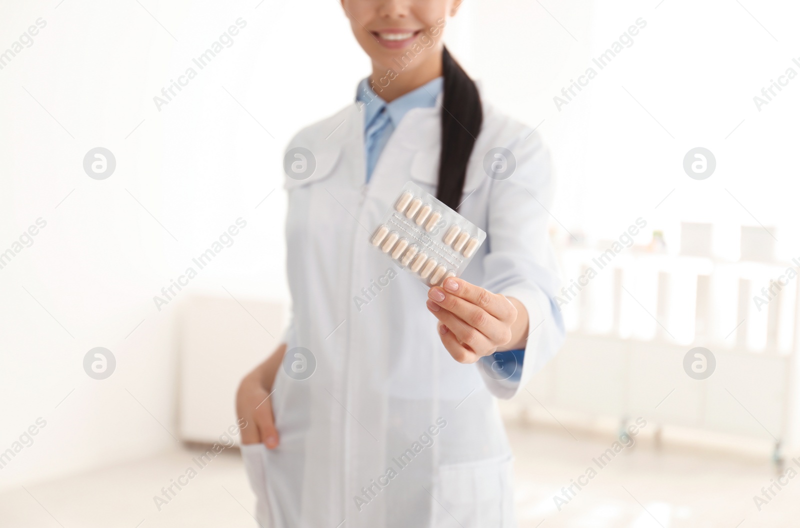 Photo of Professional pharmacist with pills in drugstore, closeup