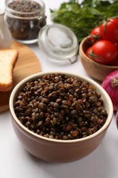 Photo of Delicious lentils in bowl served on table, closeup