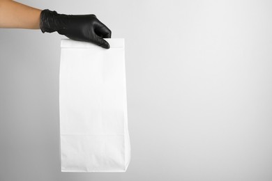 Photo of Woman holding paper bag on white background, closeup. Space for text