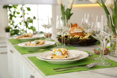 Photo of Festive Easter table setting with quail eggs in kitchen