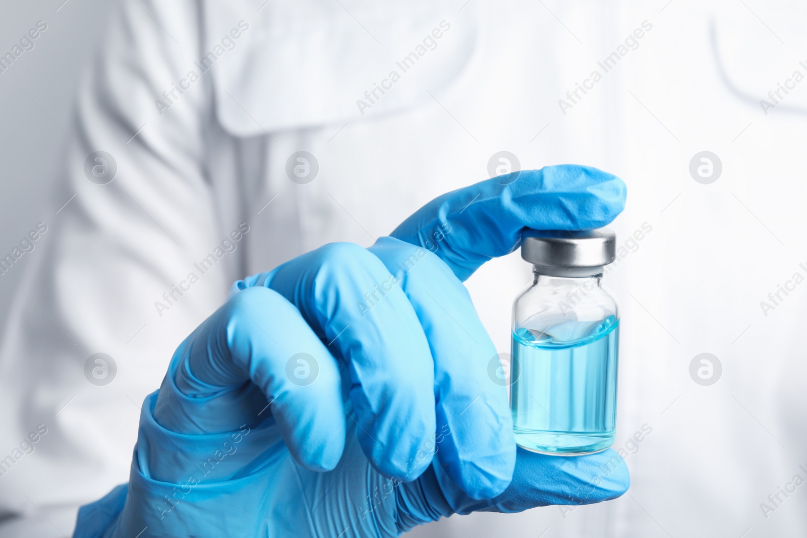 Photo of Doctor holding vial with medication, closeup. Vaccination and immunization