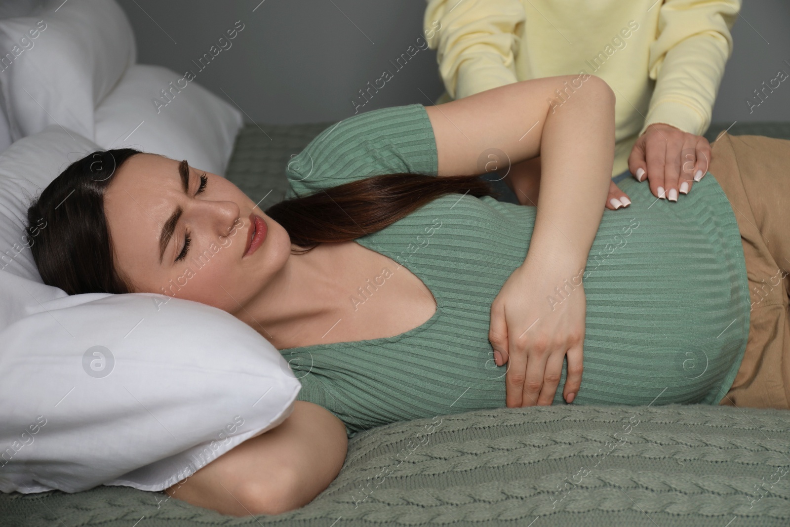 Photo of Doula taking care of pregnant woman indoors. Preparation for child birth