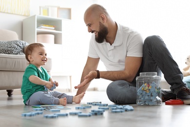 Photo of Dad and his little son playing together at home