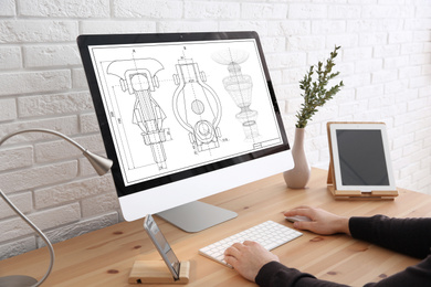 Image of Male engineer working with technical drawing on computer indoors, closeup