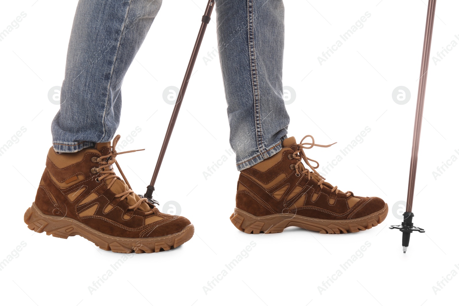 Photo of Man wearing stylish hiking boots with trekking poles on white background, closeup