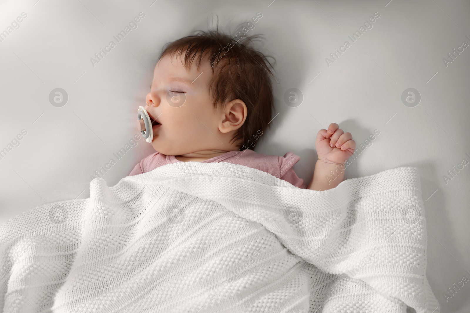 Photo of Cute little baby sleeping in bed, top view
