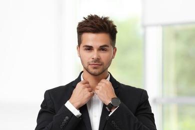 Portrait of handsome young man in elegant suit indoors