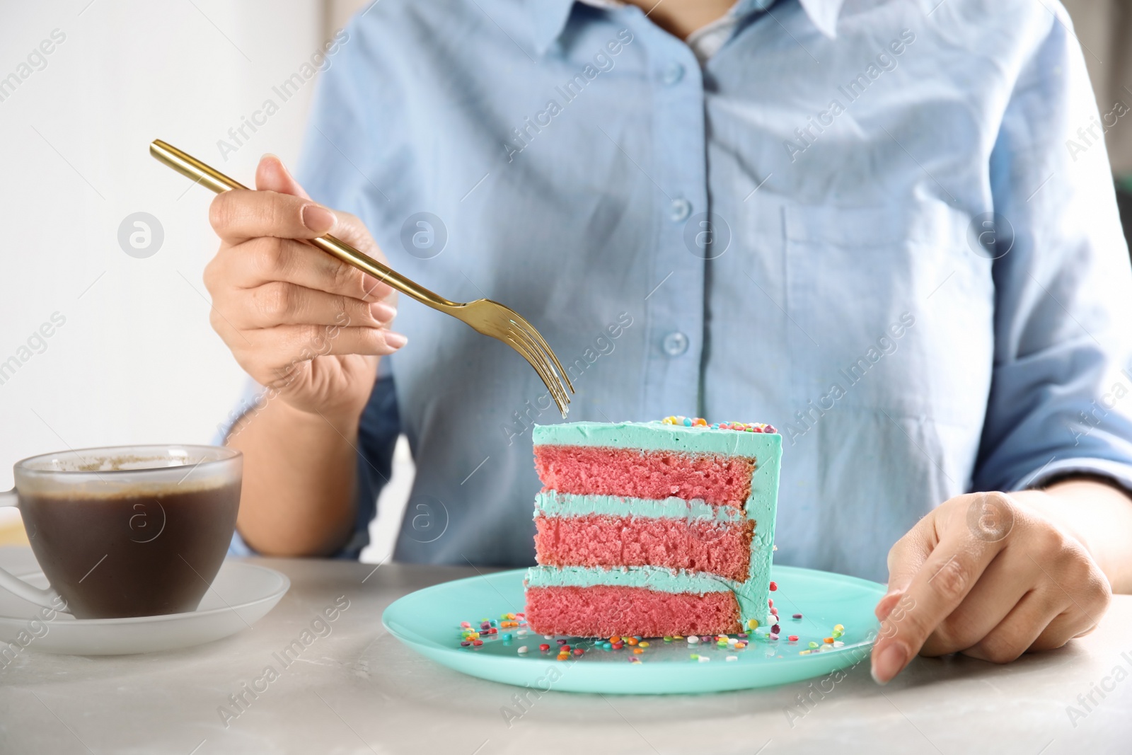 Photo of Woman eating fresh delicious birthday cake at table, closeup