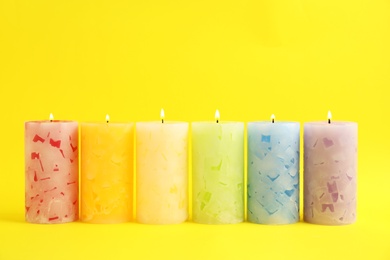 Alight scented wax candles on color background