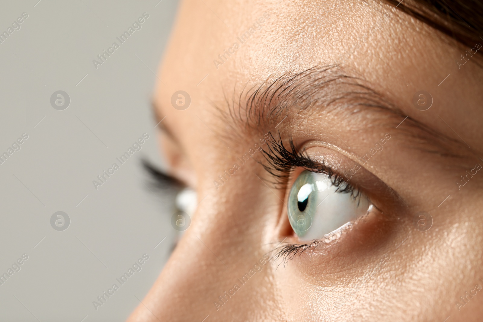 Photo of Beautiful woman with grey eyes on color background, closeup. Space for text