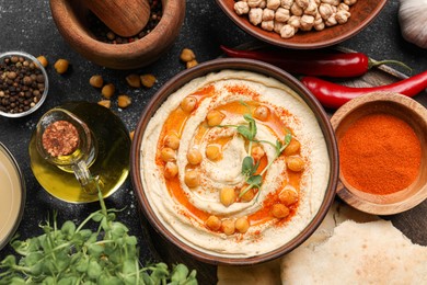 Delicious hummus with chickpeas and different ingredients on grey table, flat lay