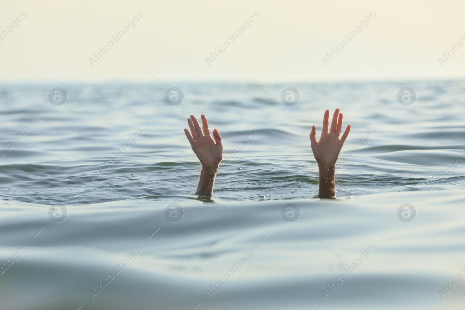 Photo of Drowning woman reaching for help in sea