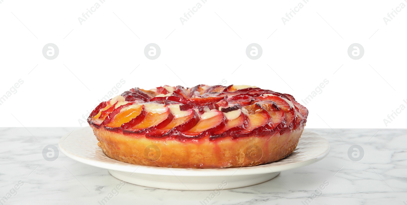 Photo of Delicious plum cake on marble table against white background