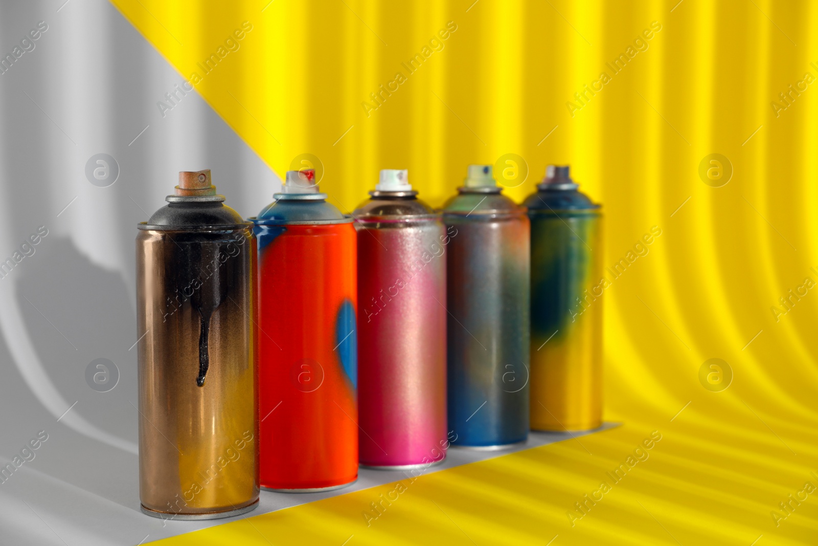 Photo of Used cans of spray paints on color background