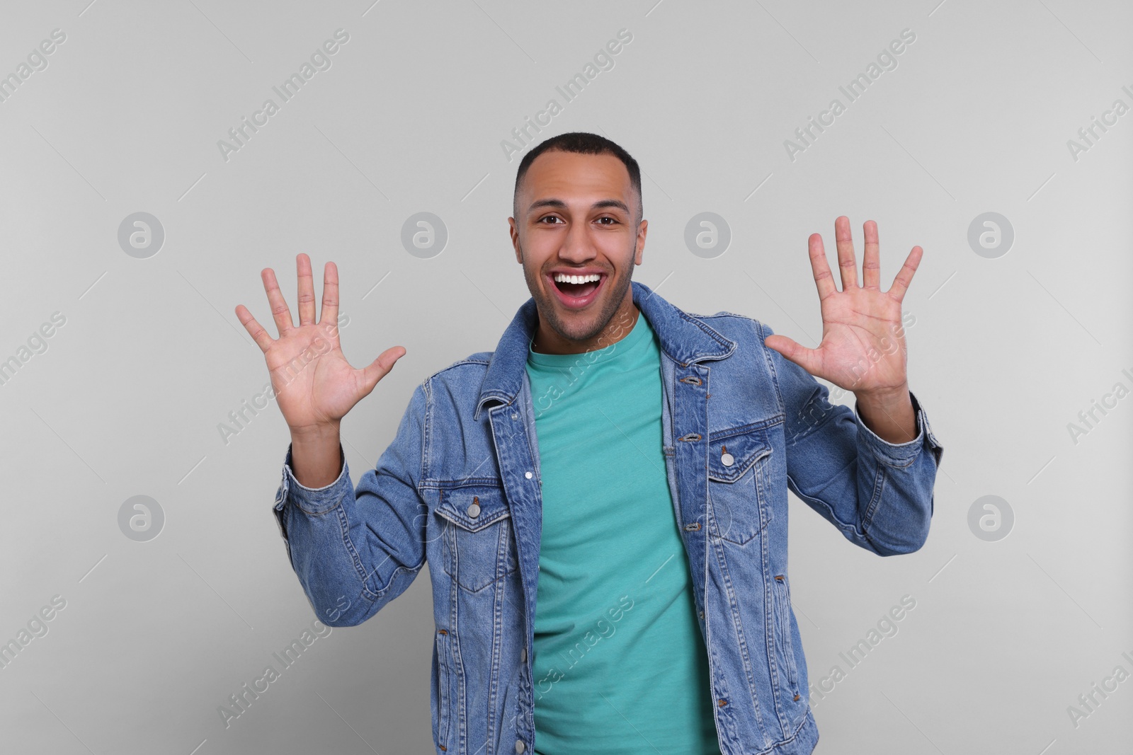 Photo of Man giving high five with both hands on grey background