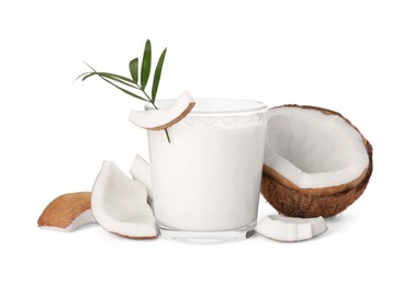 Photo of Glass of delicious vegan milk, coconut pieces and green leaf on white background