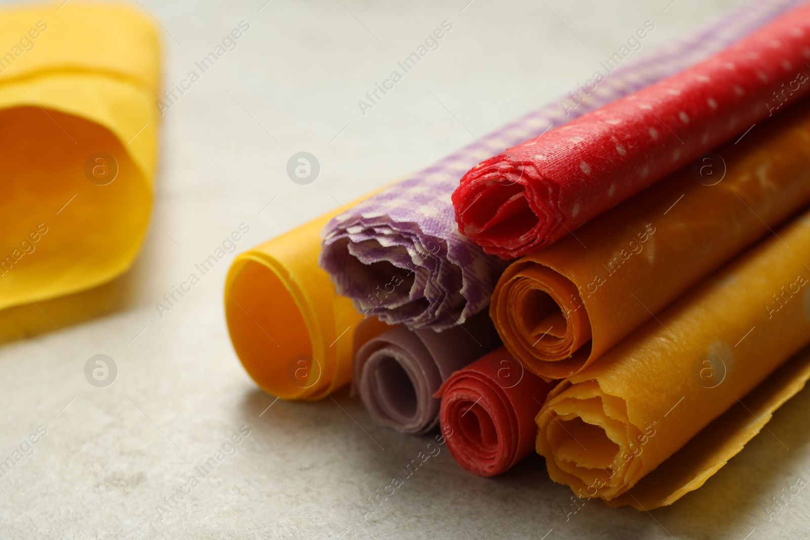 Photo of Colorful beeswax food wraps on light table, closeup