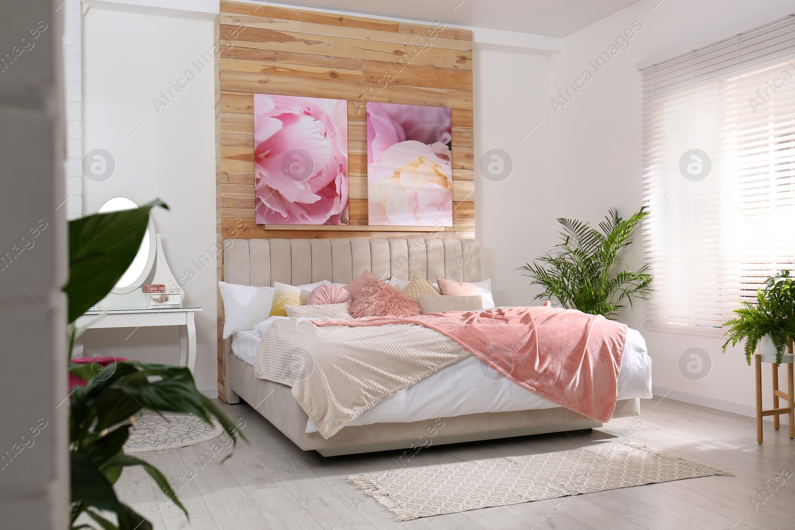 Photo of Stylish room interior with large comfortable bed and beautiful paintings