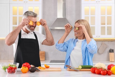 Photo of Happy affectionate couple having fun while cooking together in kitchen
