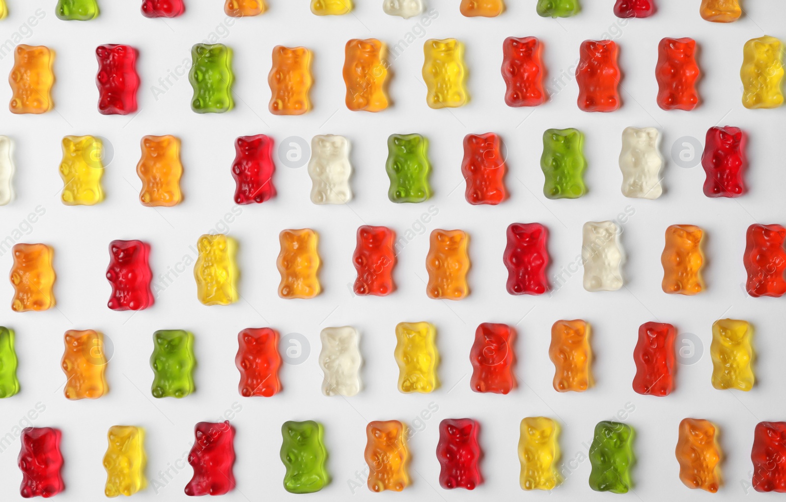 Photo of Delicious color jelly bears on white background, top view