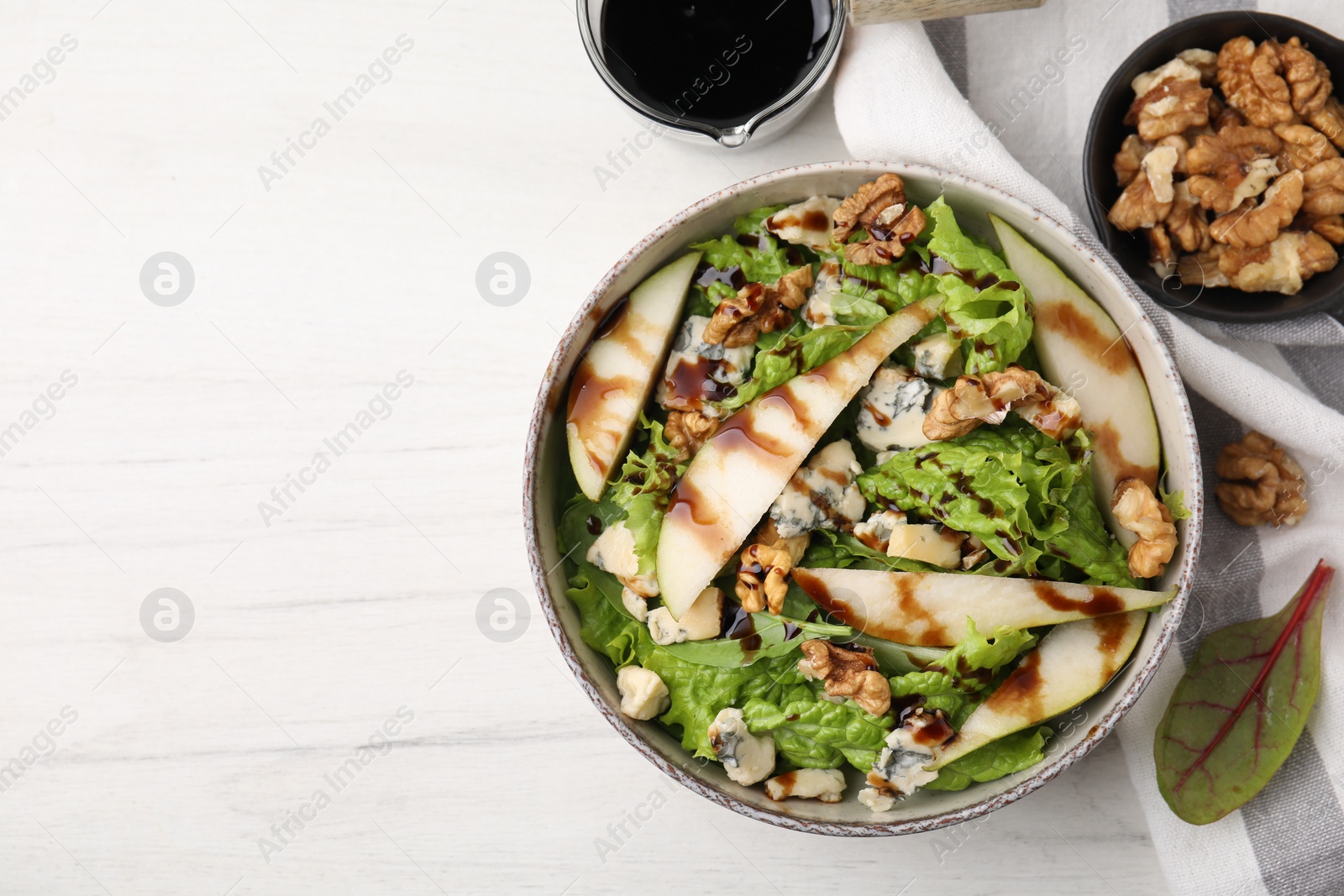 Photo of Delicious pear salad with sauce in bowl on light table, flat lay. Space for text