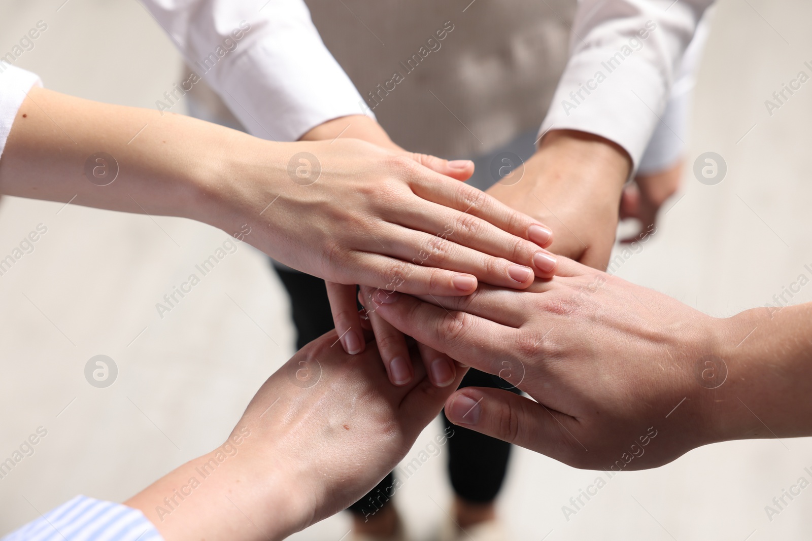 Photo of Group of people holding hands together indoors, above view. Unity concept