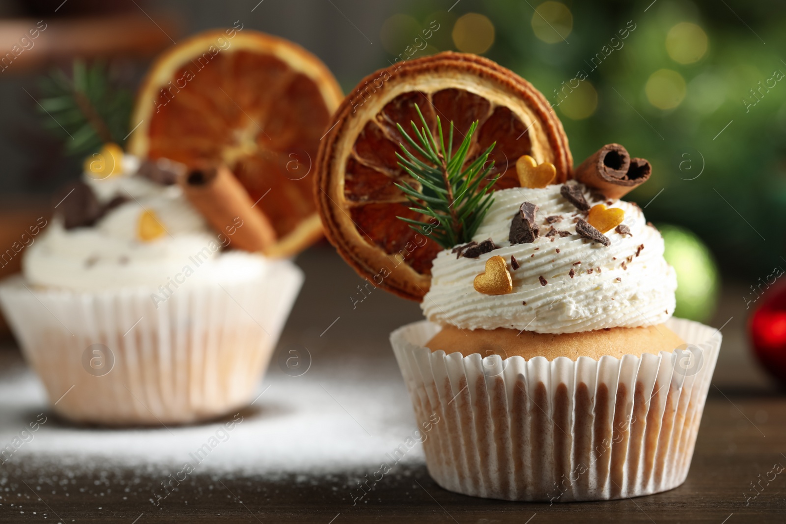 Photo of Beautifully decorated Christmas cupcake on wooden table, closeup. Space for text