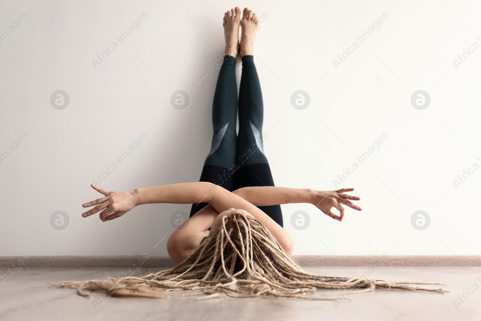 Photo of Young woman practicing yoga indoors