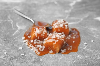 Delicious candies with caramel sauce and salt on table