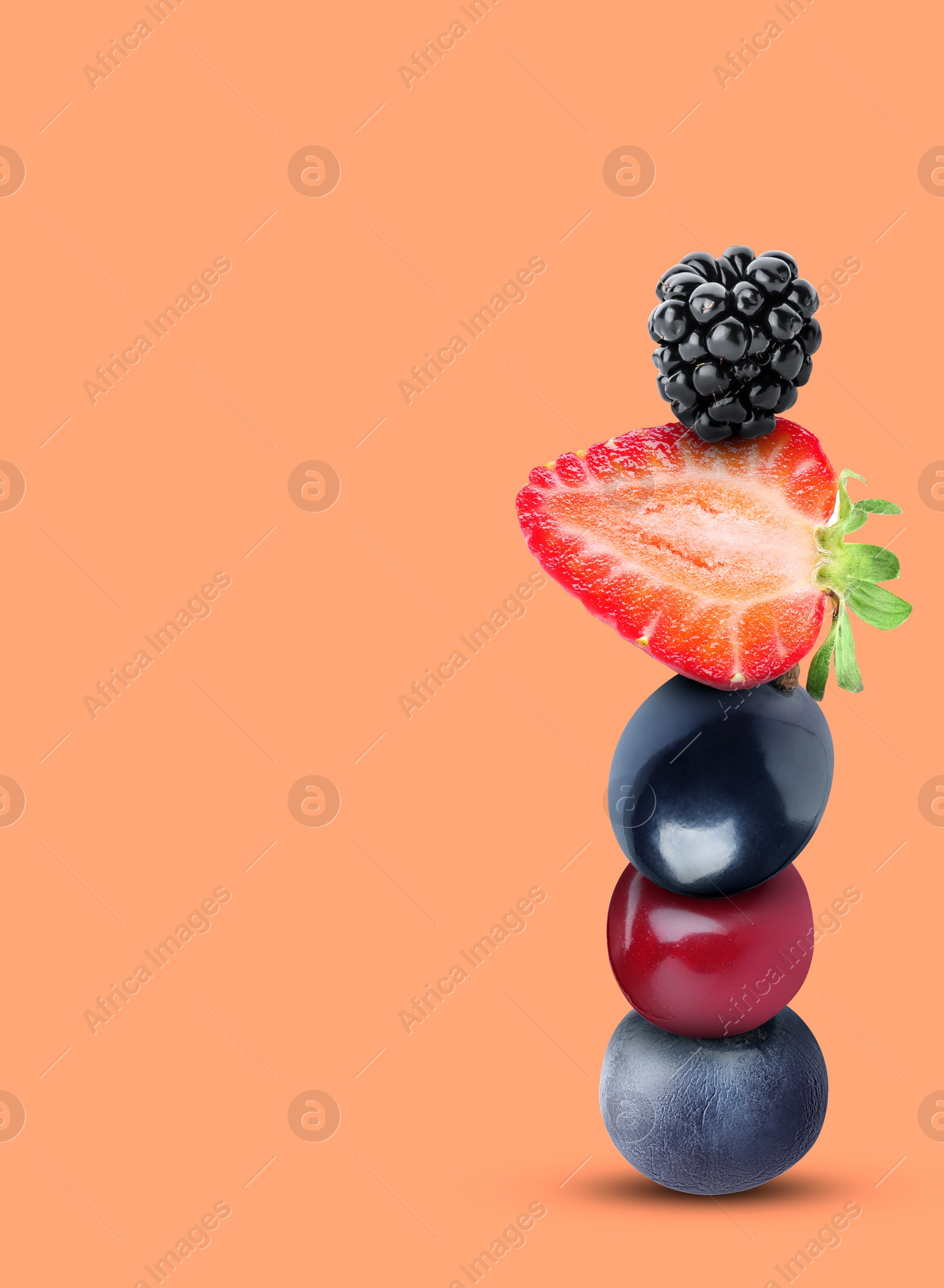 Image of Stack of different fresh tasty berries on light coral background, space for text