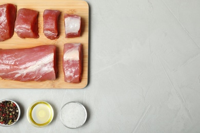 Photo of Flat lay composition with fresh raw meat and space for text on gray background