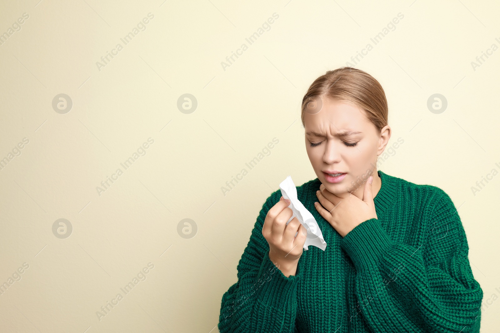 Image of Young woman suffering from sore throat on light background, space for text. Cold symptoms