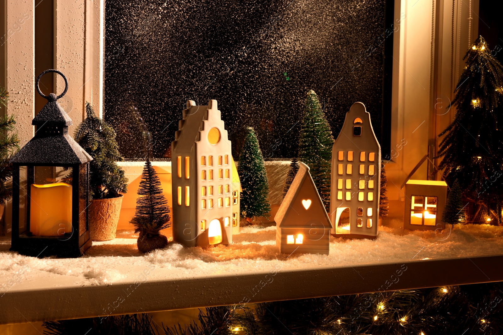 Photo of House shaped lanterns and Christmas decor on windowsill indoors