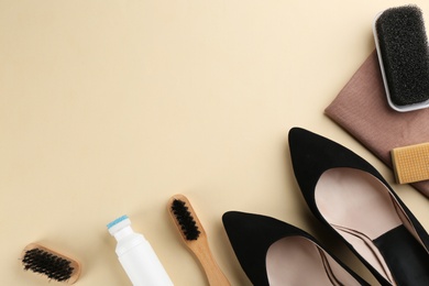 Photo of Stylish footwear with shoe care accessories on beige background, flat lay. Space for text