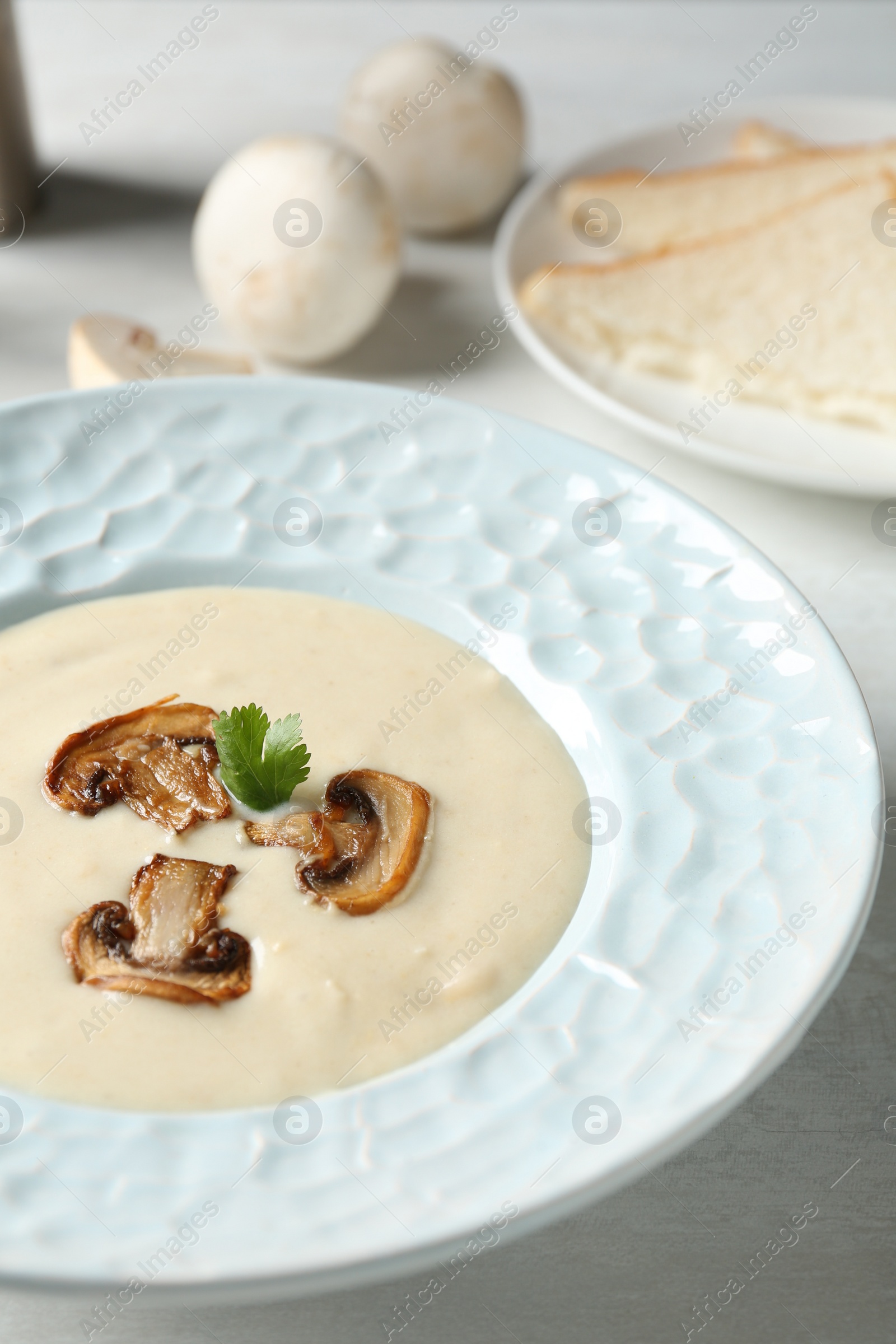Photo of Delicious cream soup with mushrooms on table, closeup