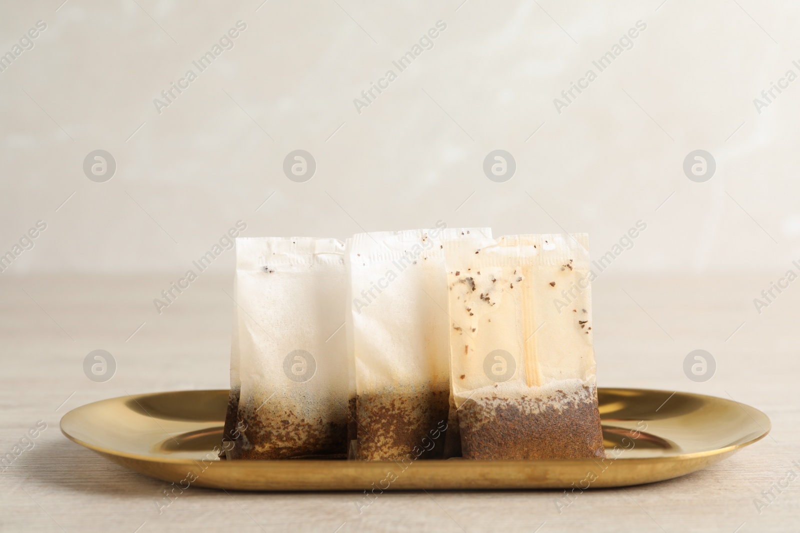 Photo of Plate with used tea bags on light table, closeup