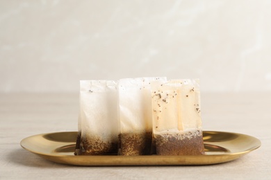 Plate with used tea bags on light table, closeup