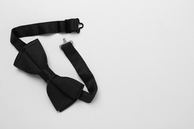 Photo of Stylish black bow tie on white background, top view. Space for text