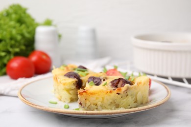 Photo of Tasty sausage casserole with green onions and vegetables served on white marble table, closeup