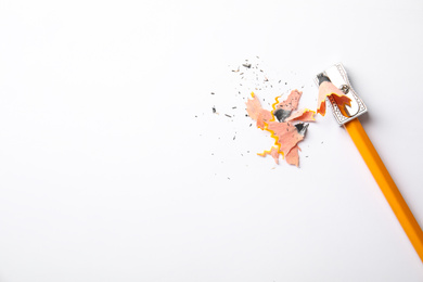 Photo of Graphite pencil, shavings and sharpener on white background, top view. Space for text