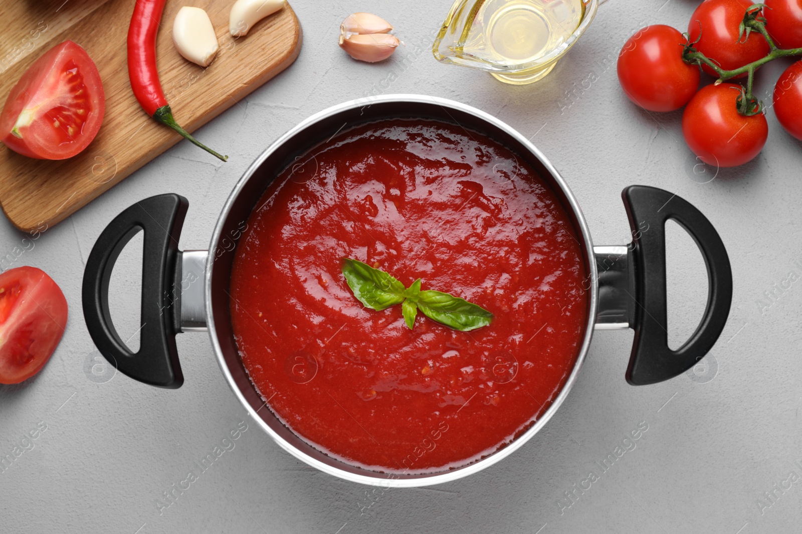 Photo of Delicious tomato sauce on light grey table, flat lay