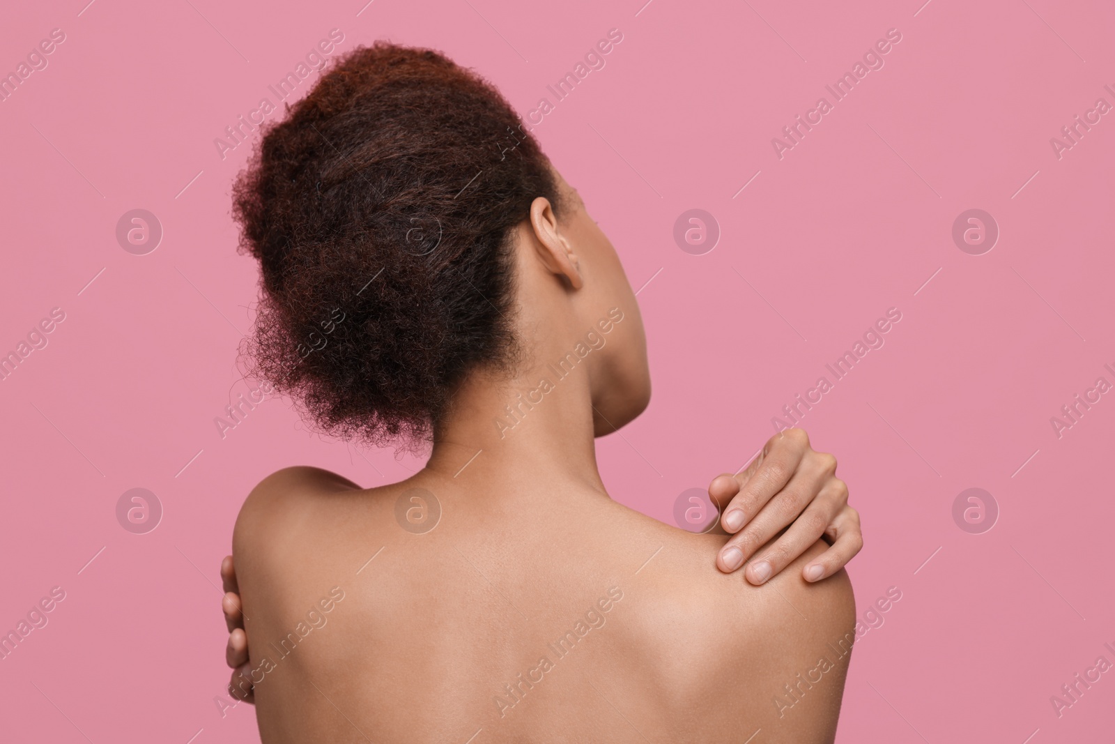 Photo of Beautiful young woman with stylish hairstyle on pink background, back view