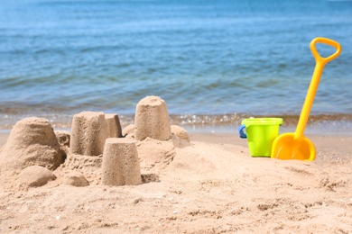 Photo of Little sand figures and plastic toys on beach near sea