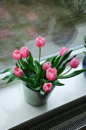 Photo of Beautiful bouquet with pink tulips on white window sill indoors, above view