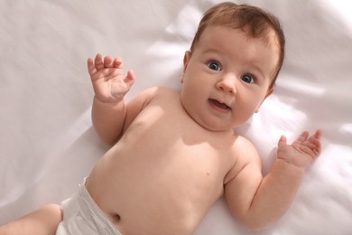 Photo of Cute little baby on bed, top view