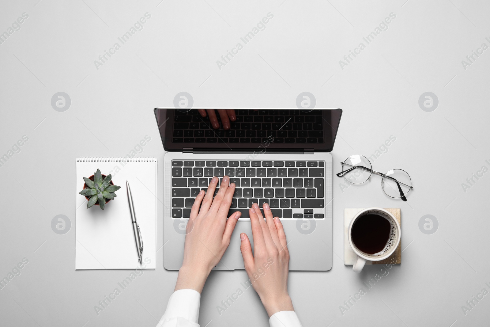 Photo of Woman using laptop at light table, top view