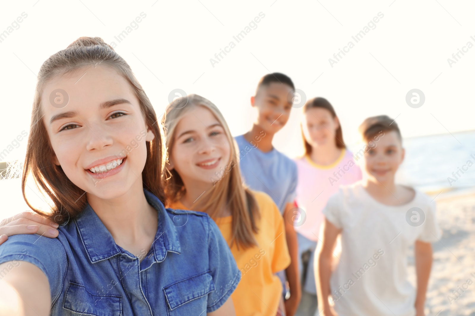 Photo of Group of children taking selfie on beach. Summer camp