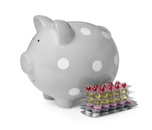Photo of Piggy bank and pills on white background. Medical insurance